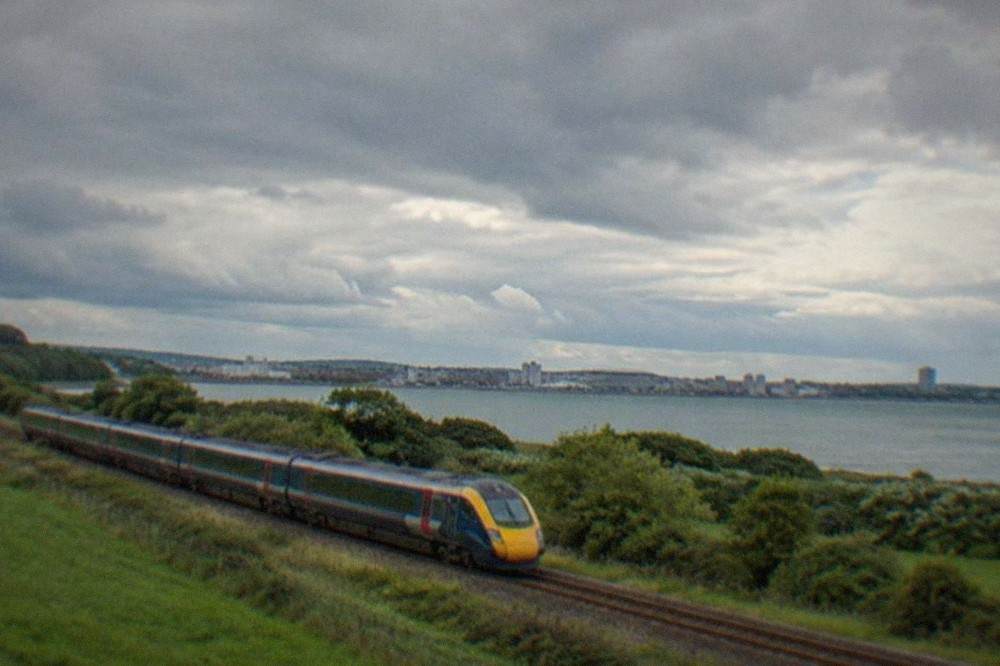 A long-distance passenger train travelling through green countryside