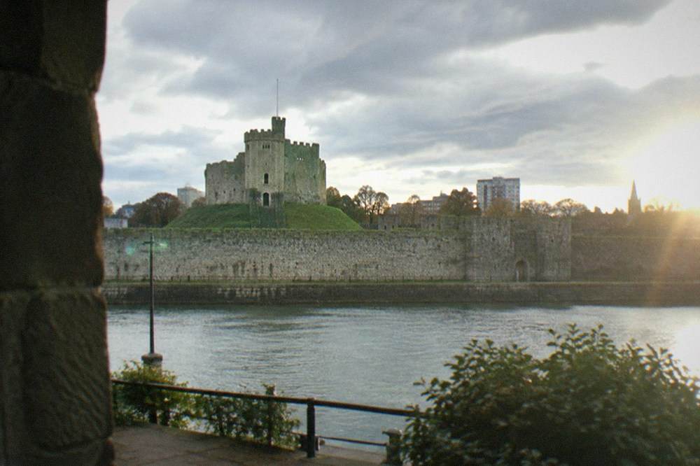 A historic stone castle keep rising above city rooftops
