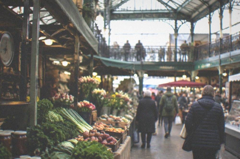 A traditional covered market hall with food stalls and shoppers