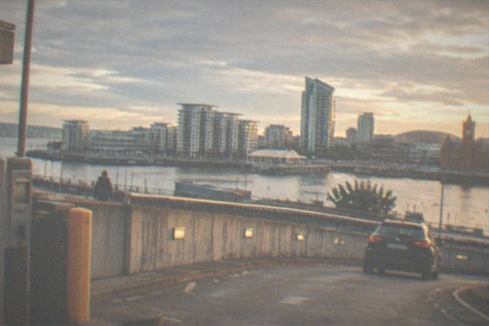 Car park entrance ramp with a pay machine and city buildings visible above