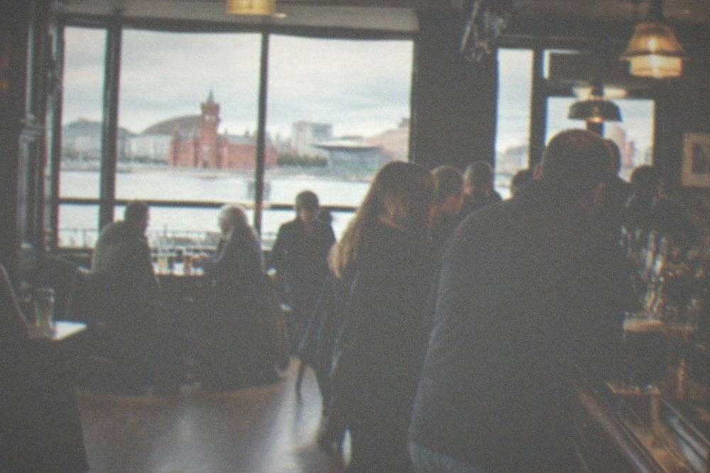 A traditional city pub interior with wooden fittings and a busy bar