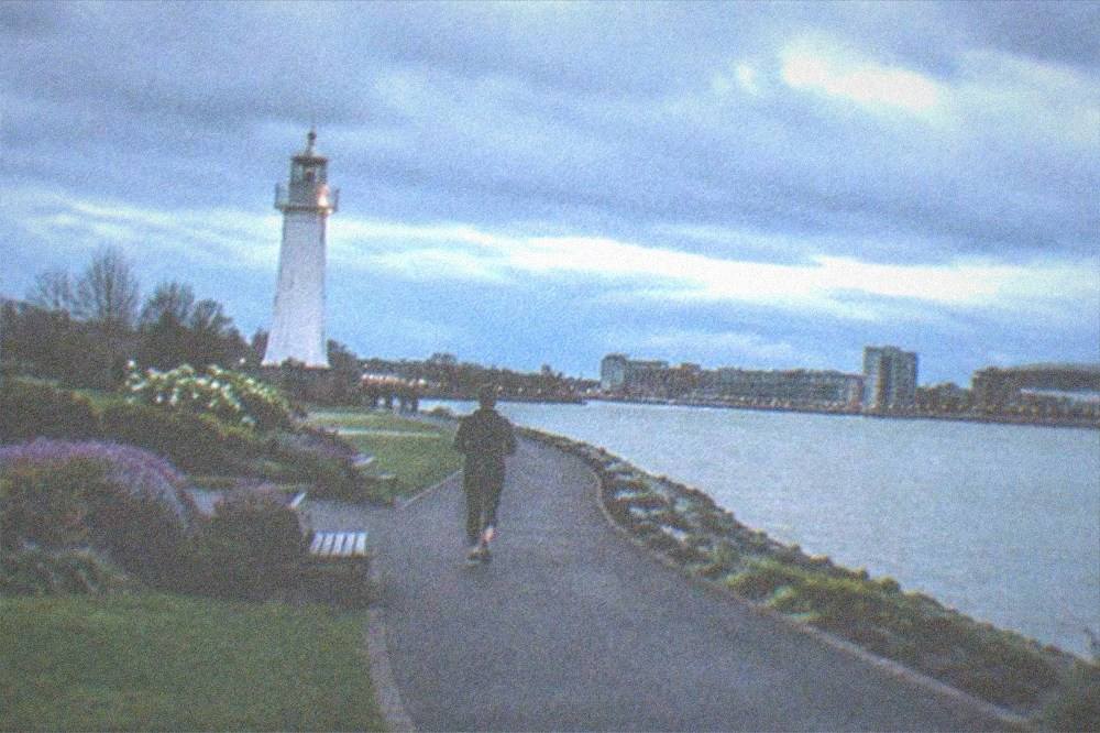 A lakeside park with a lighthouse memorial and gardens