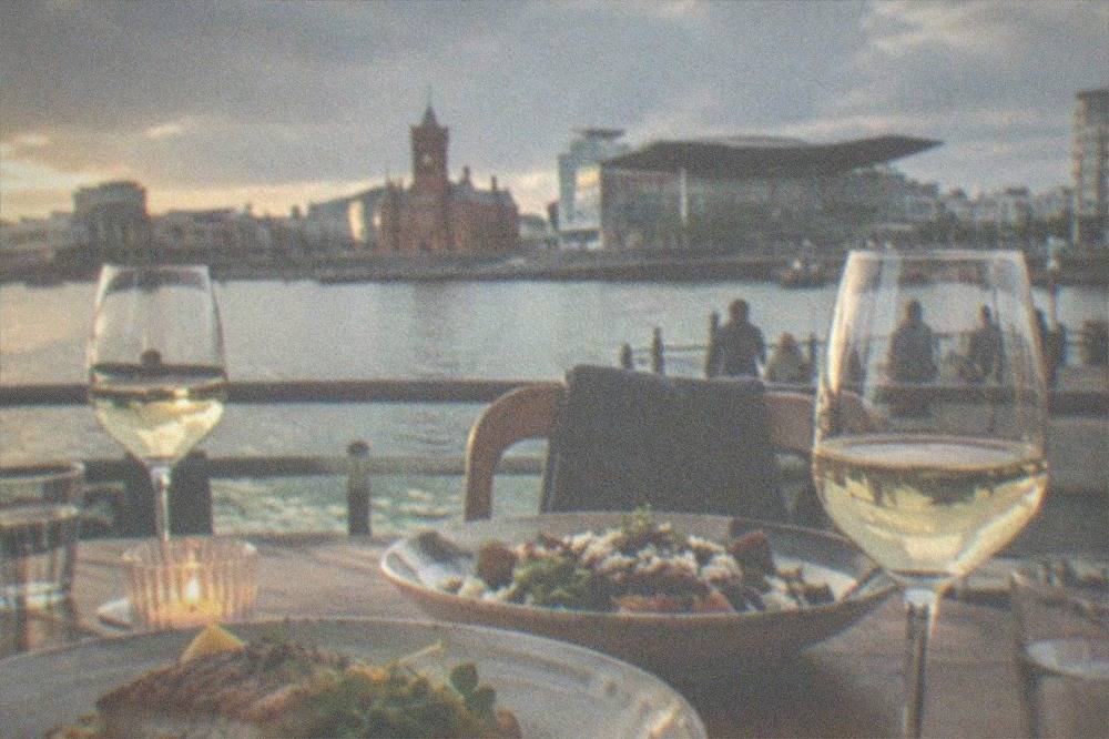 A small neighbourhood restaurant table set with wine glasses and plates of seasonal food