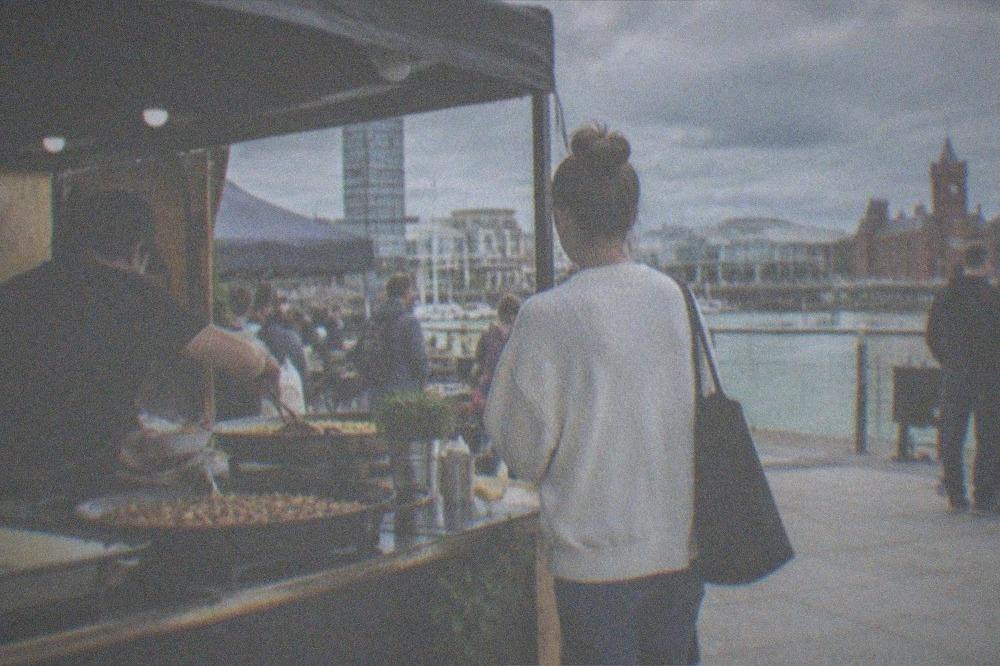 An outdoor food stall serving dishes to customers at a street festival