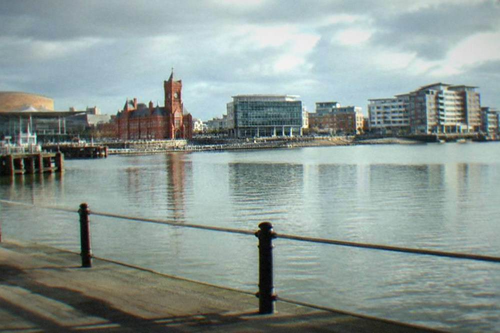 The waterfront buildings of Cardiff Bay viewed across a calm stretch of water