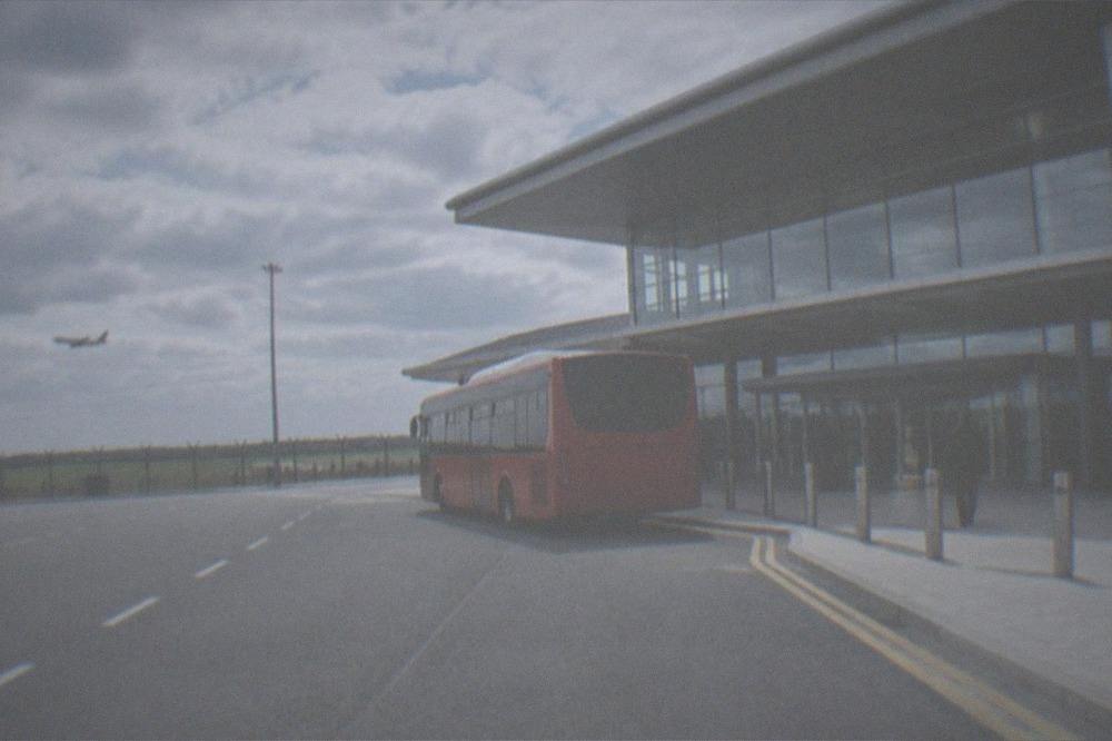 The entrance to Cardiff Airport terminal with a red T9 bus outside