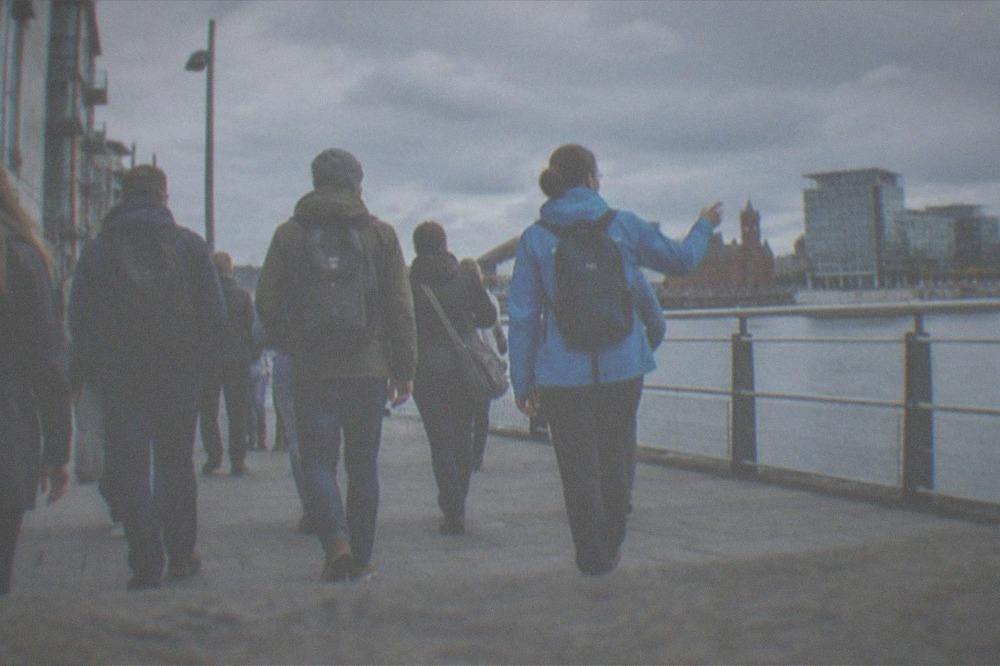 A guide leading a small walking group along a city-centre street