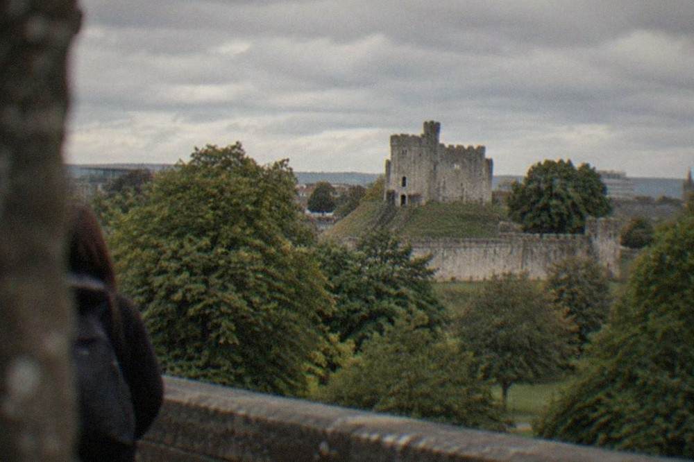 Cardiff Castle keep rising above the city skyline with Bute Park greenery in the foreground