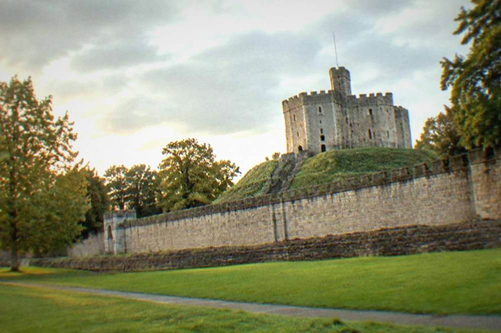 The Norman keep of Cardiff Castle seen from the grassy inner ward in morning light