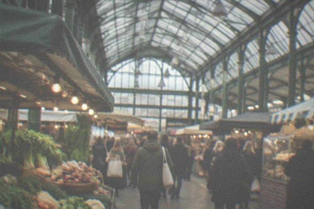 The restored Victorian glass roof of Cardiff Market above busy food stalls