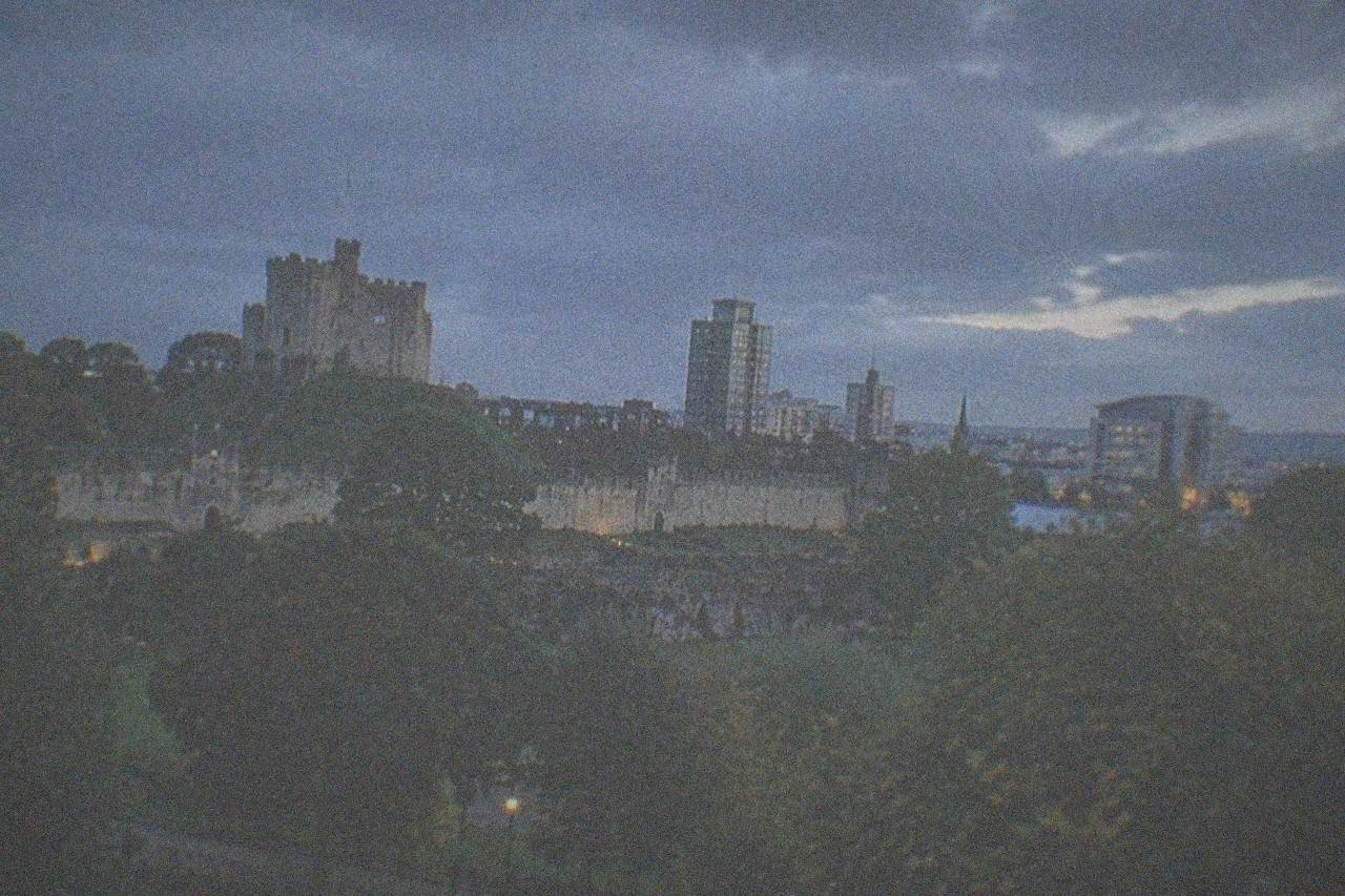 Cardiff Castle keep rising above the city skyline with Bute Park greenery in the foreground