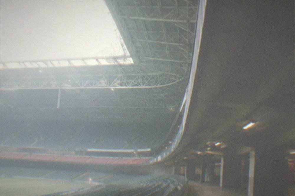 Empty stadium seating and covered concourse inside a large indoor sports stadium