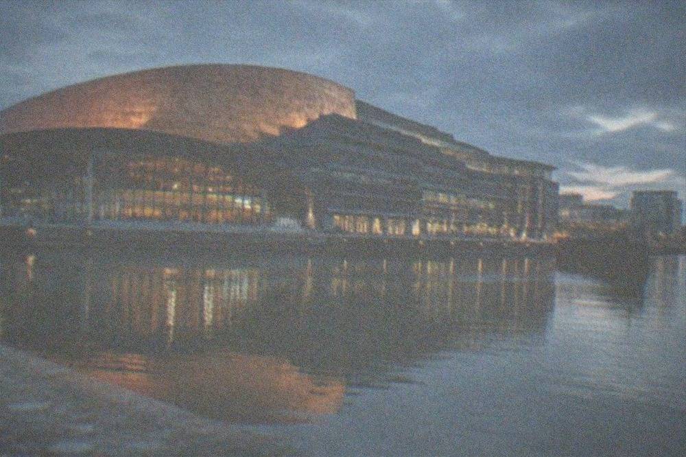 The Wales Millennium Centre facade reflected in the water of Cardiff Bay