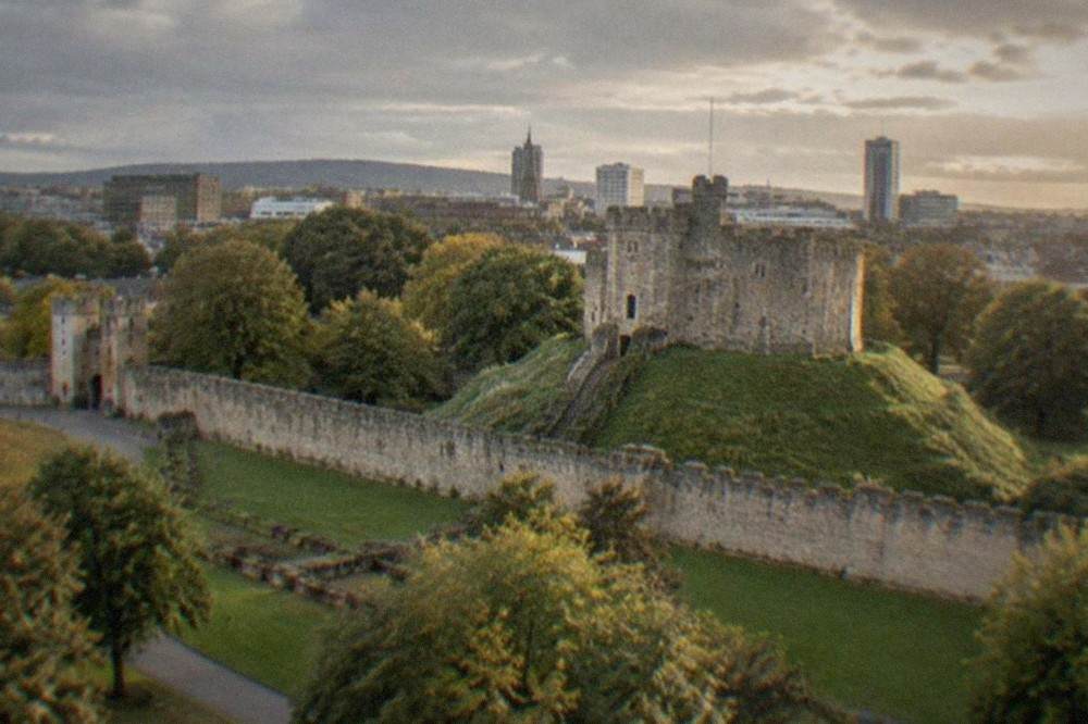 Cardiff Castle keep with the city skyline behind it on a bright morning