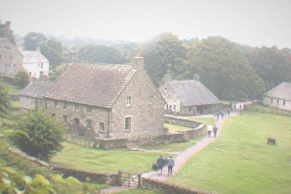 Historic stone buildings across open parkland at St Fagans